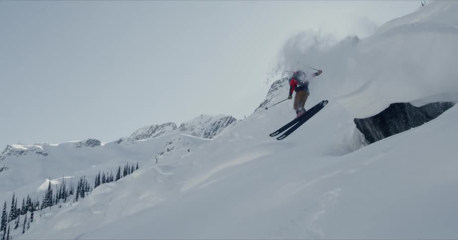 A man with red jacket doing a snow board trick
