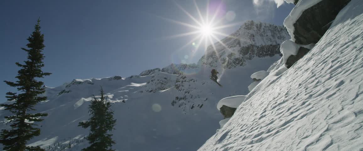 A person is snowboarding off of a mountain