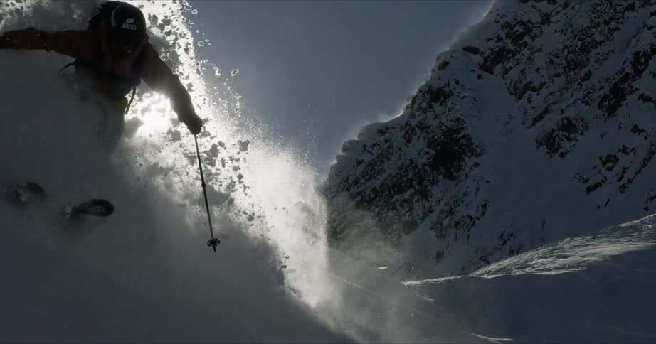 A skier makes a turn on fresh powder as they ski down a slope