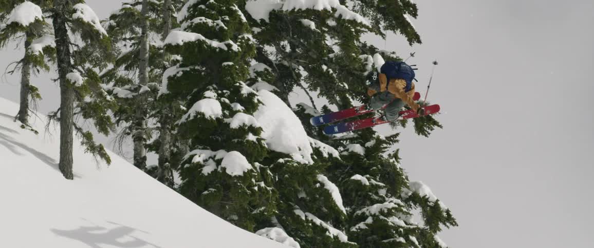 A skier is jumping off a ridge in a remote area on a winters day