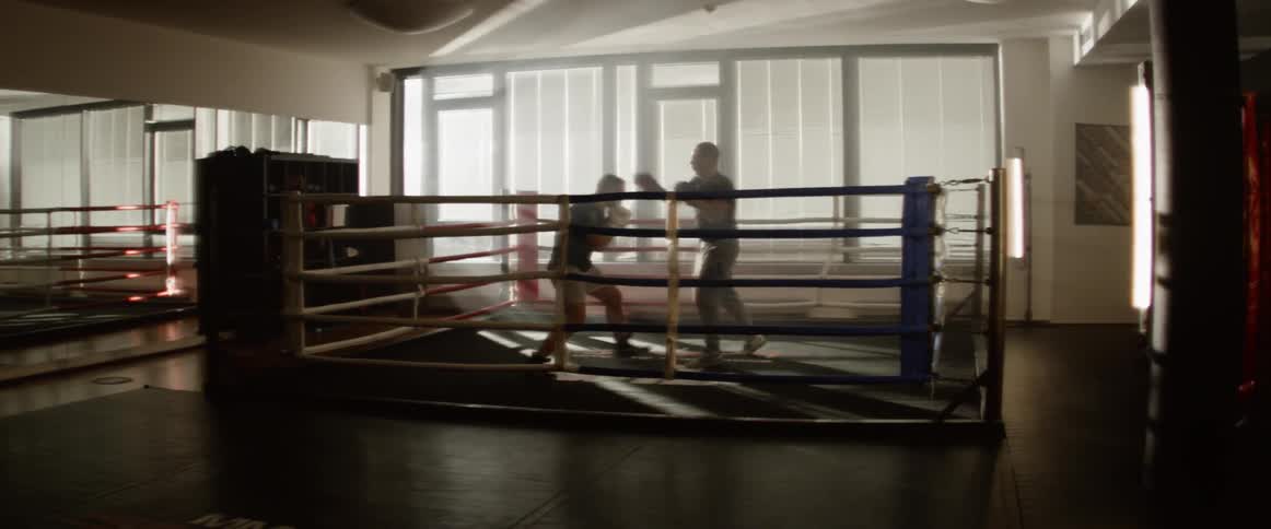 Two men boxing in a boxing ring indoors in a gym