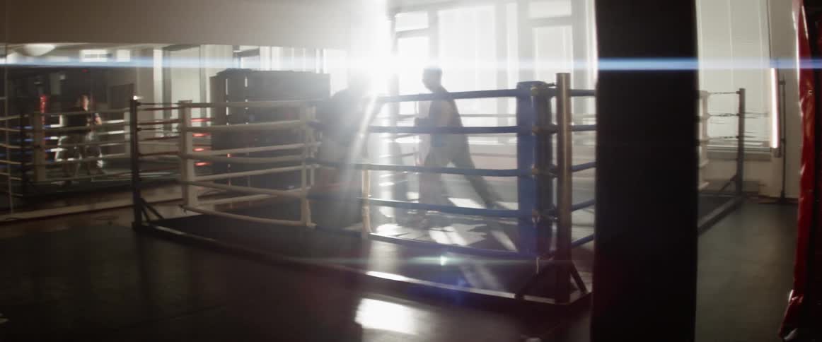 Boxers practicing in a ring inside a gym