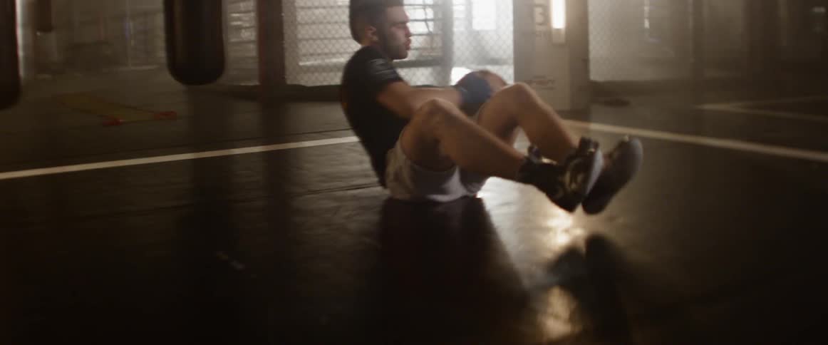 A man tosses a weighted ball back and forth while sitting to athletically train