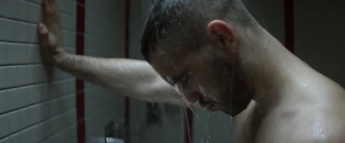 Man has a shower and puts his hand on the wall in the bathroom