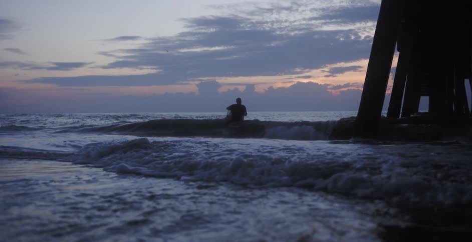 A person is wading into the ocean