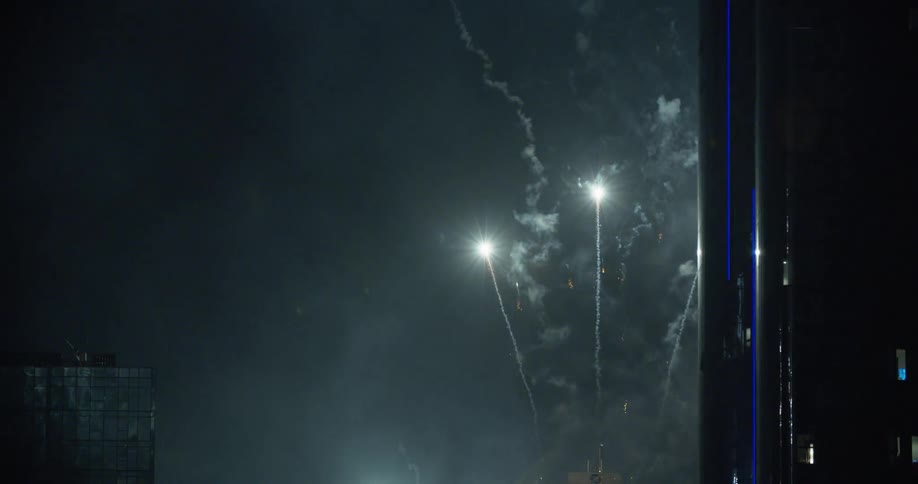 Fireworks shoot up into the night sky over a city