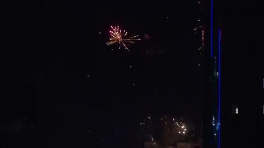 The fireworks explode in the night sky