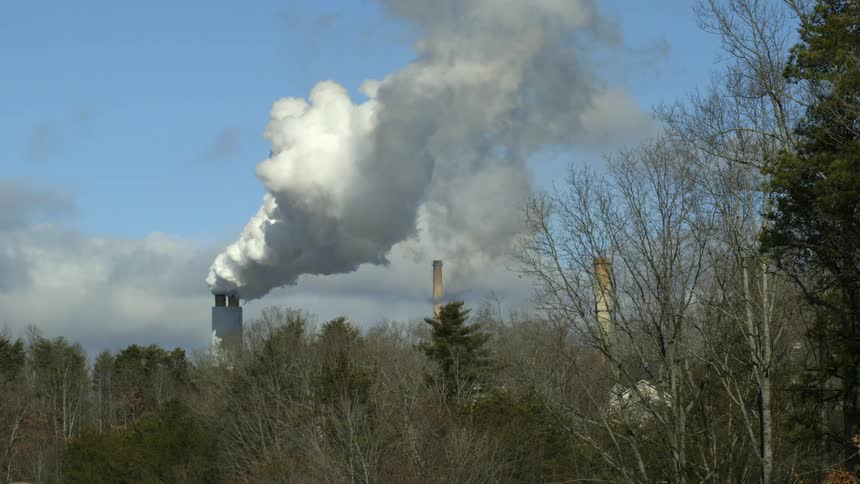 Smoke bellows from a smokestack
