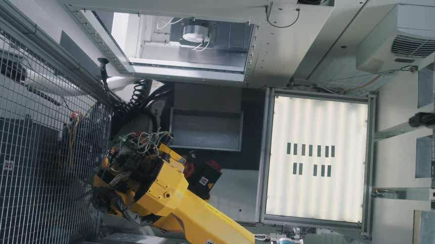A robotic arm swings around and reaches into an opening