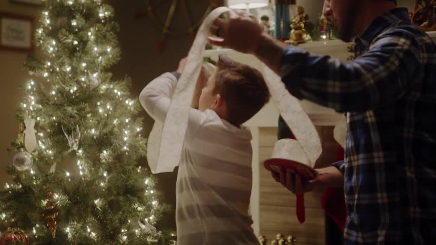 Father and son are decorating a christmas tree