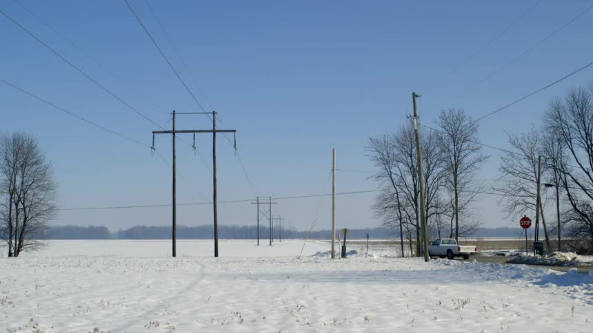 A white truck driving next to a snow covered area