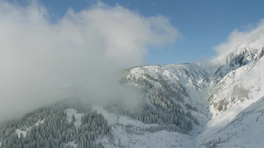 Clouds and fog over a snow covered mountain range