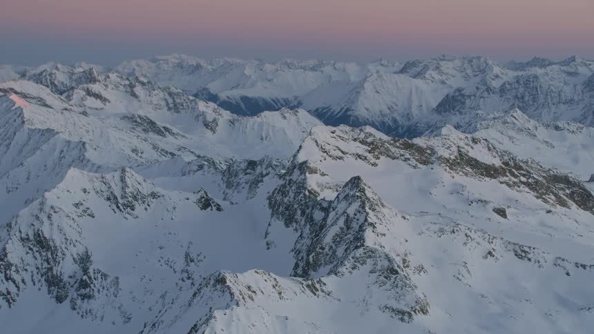 Aerial view of mountain range covered in snow
