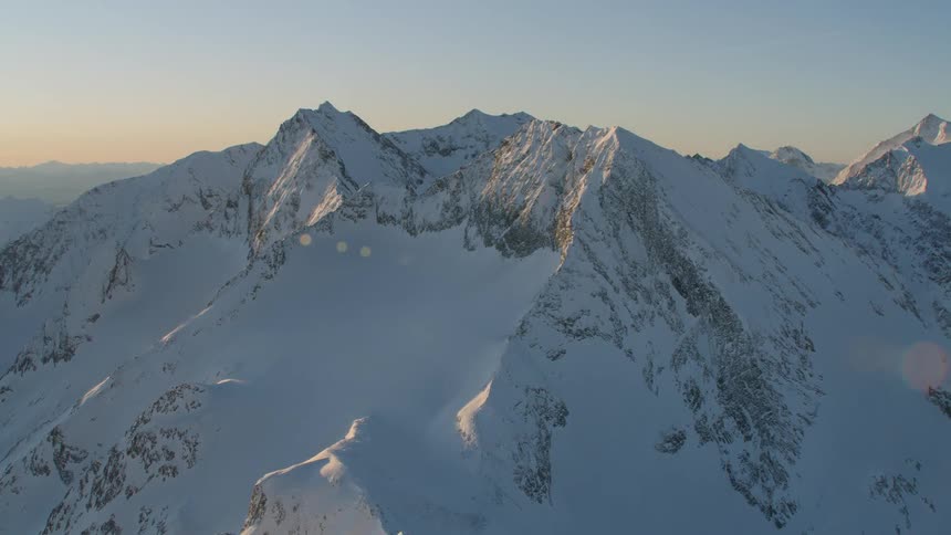 An aerial scenery of snowy mountain peak at the sunset