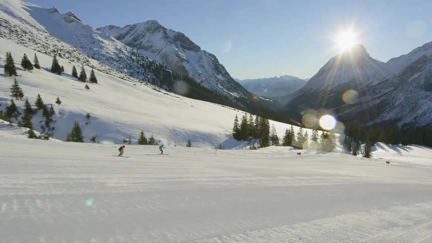 Two ski down the mountains