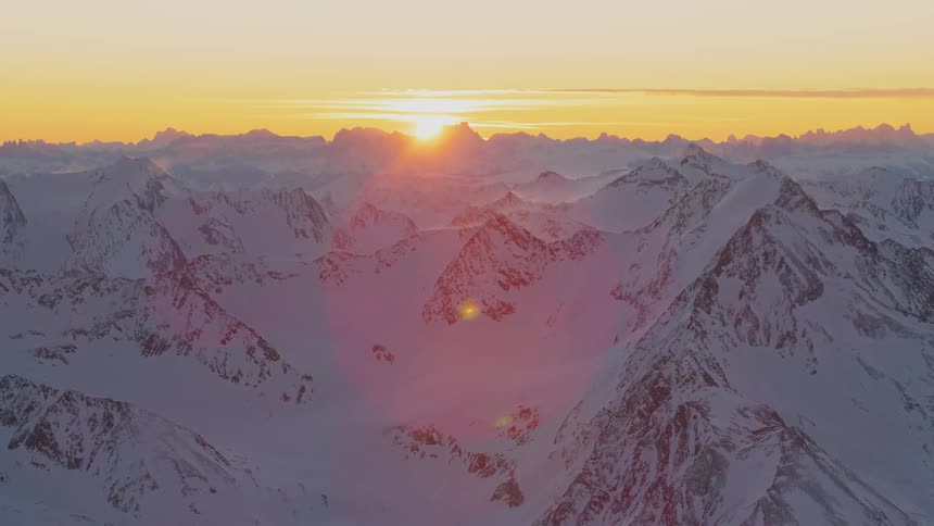 Aerial view of snow capped mountain range at sunset