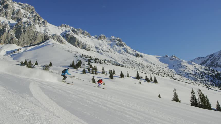 People snowboarding on the snowy hills