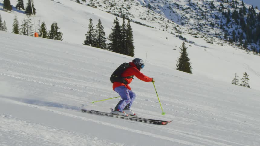 Two people ski down the slope