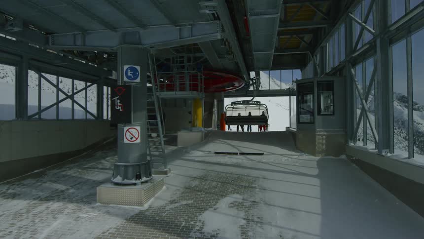 Chairlift coming in to indoor terminal to unload skiers at a ski resort