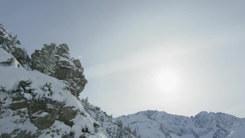 A snow covered mountain range dotted with pine trees