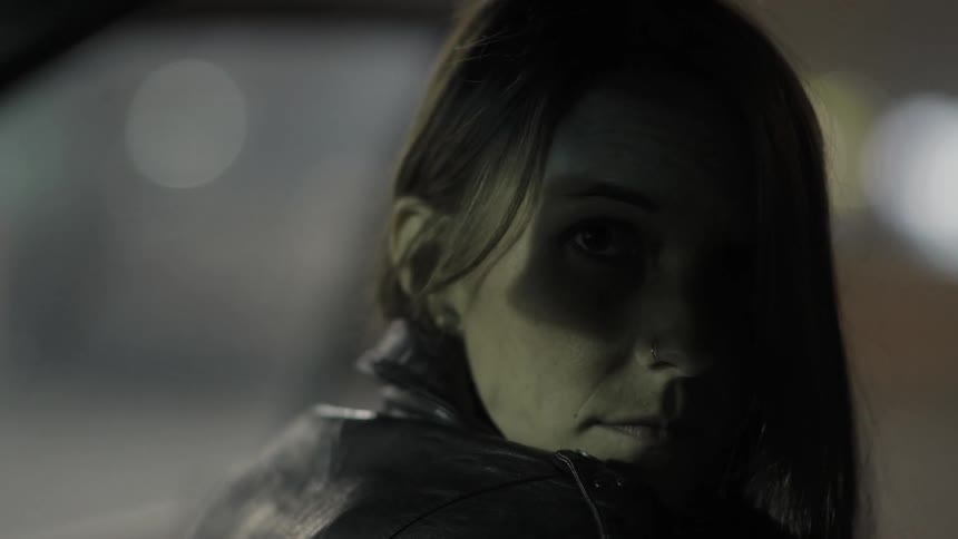 Lights cast a shadow across a woman's face