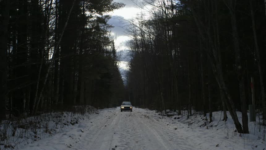 A car drives down a snowy road