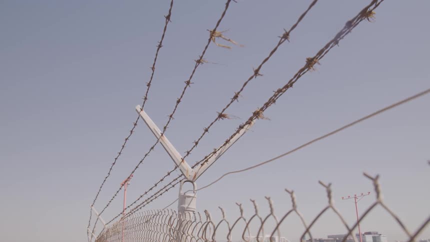 Barbed wire running over a wire fence