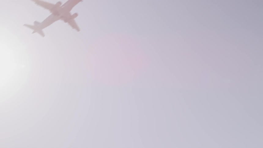 An airplane flying in the sky in front of the sun