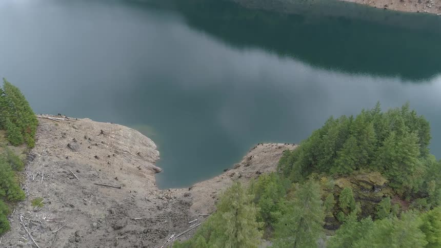 A body of water surrounded by trees and sloping banks