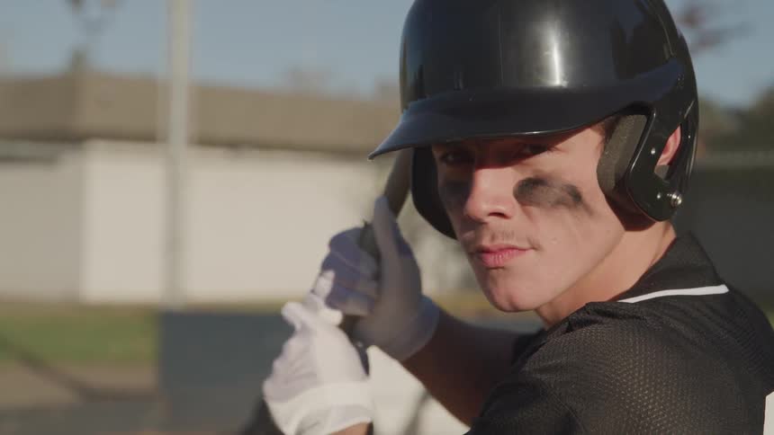A portrait of a man preparing to hit a ball with baseball bat