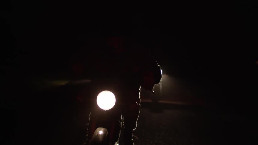 Someone is riding a motorcycle at night