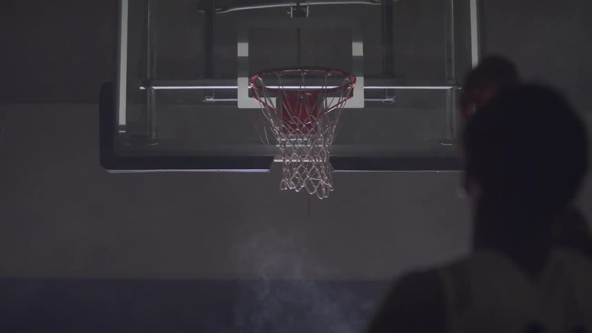 A person is playing basketball indoors