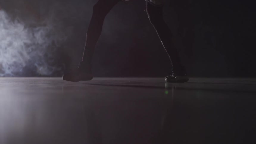 A basketball player dribbles a ball as smoke rises from the corner of the room