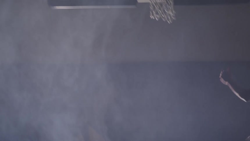 A man is playing basketball indoors