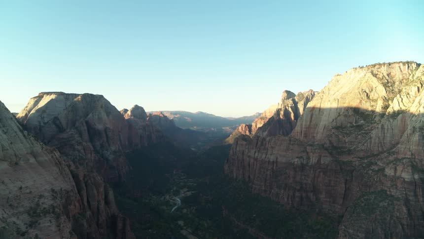 A river runs through a deep shadowed canyon in a rocky area