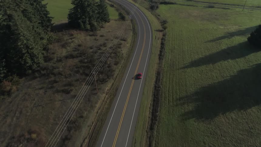 A car driving on a rural road bearing left