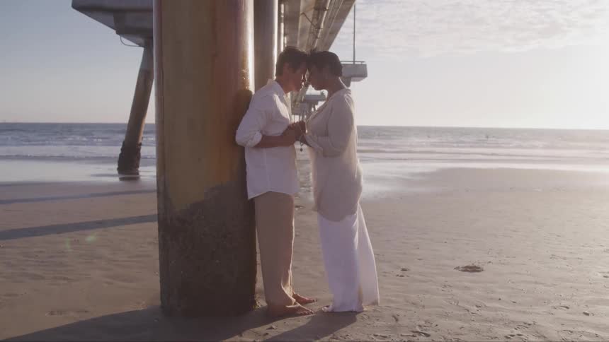A couple hugging each other on the beach