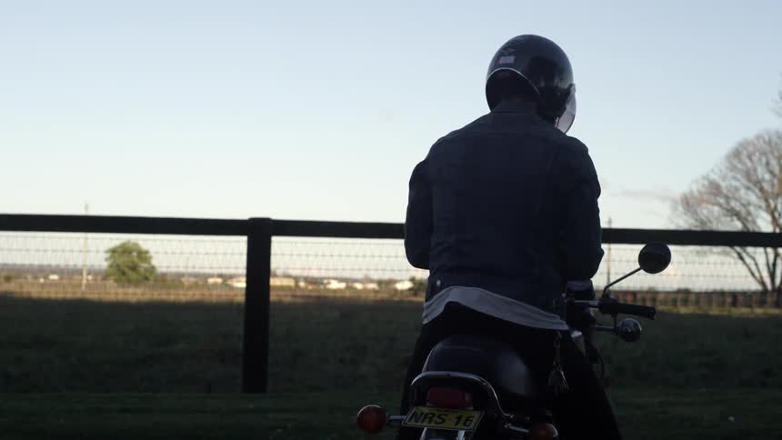 Man sitting on a parked motorcycle