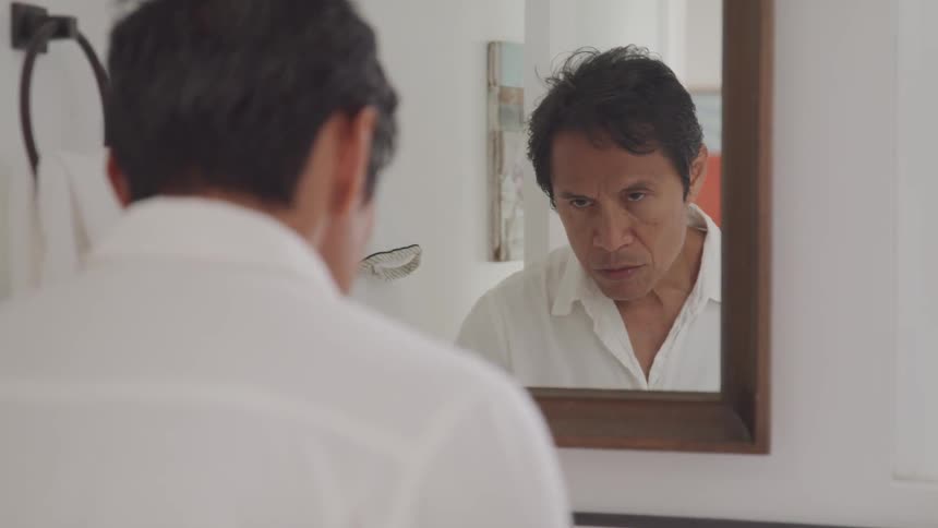 An old man look into the mirror
