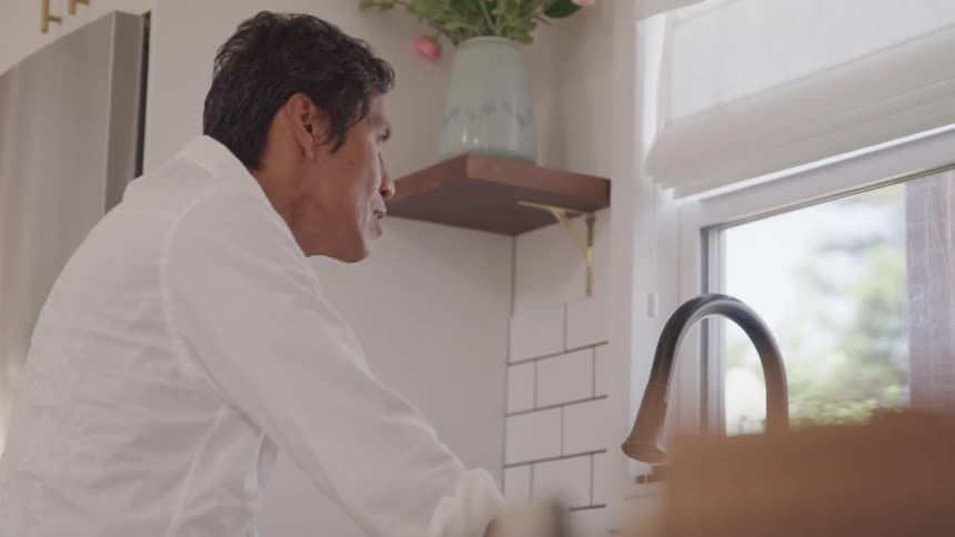 A man contemplatively thinking on the kitchen