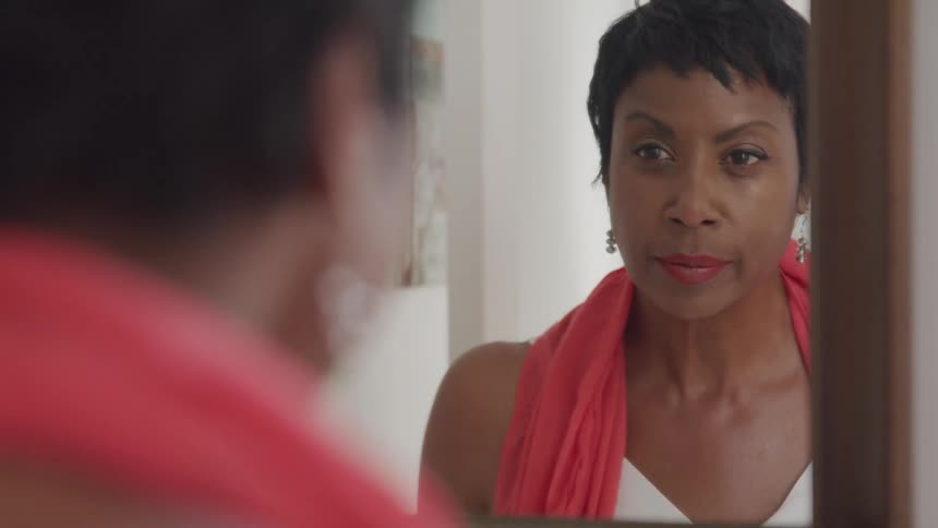 Woman faces herself in the mirror