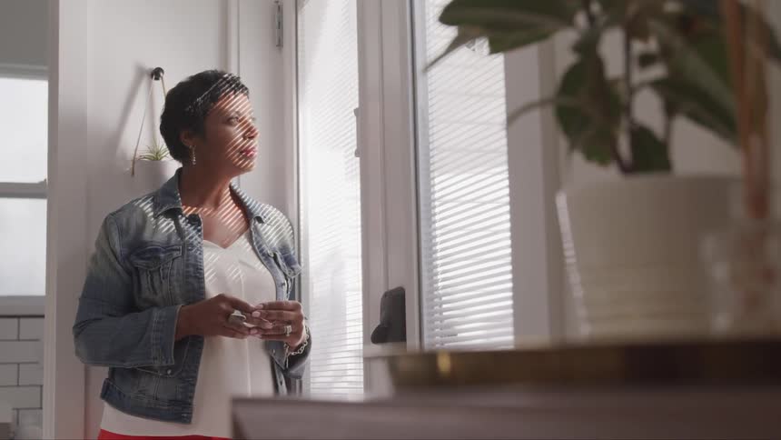 A middle aged woman looking through the window
