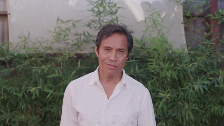 A portrait of a middle aged man wearing a white shirt