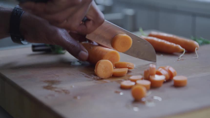 A person is cutting carrots in the kitchen