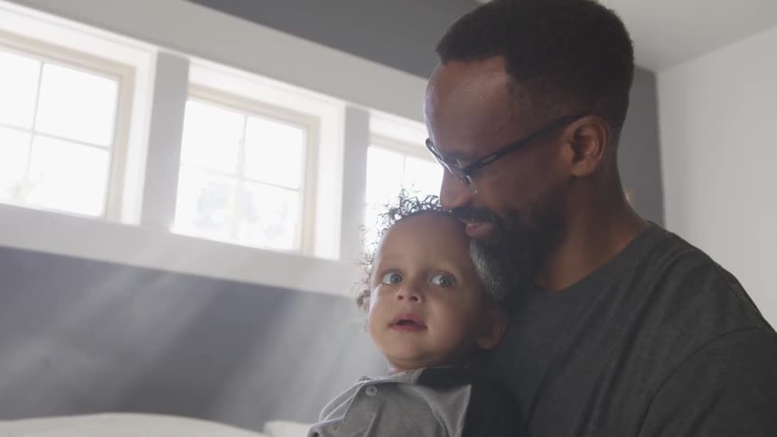 A man holding a baby and smiling