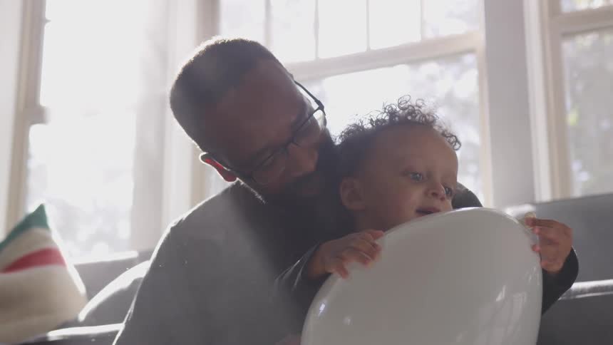 A father and son hold a balloon together