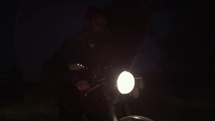 A person on a motorcycle in the dark