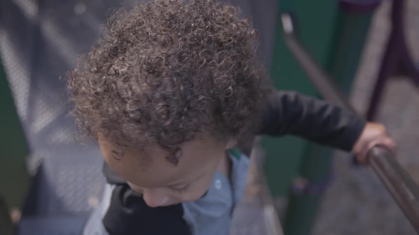 Young toddler turns around as he stands on a platform