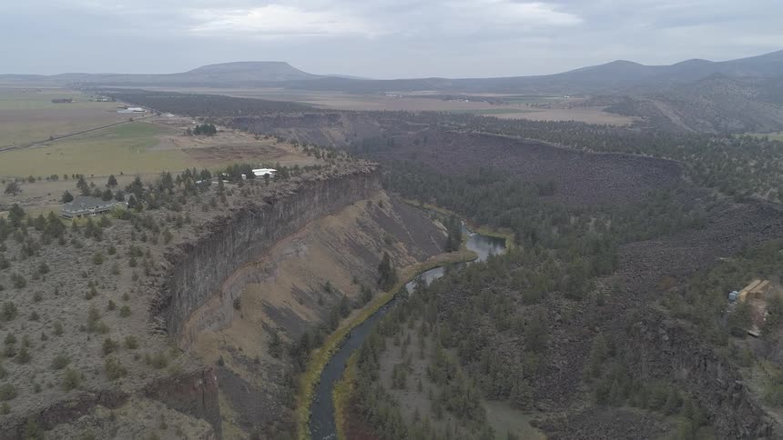 A river runs through a canyon dotted with trees