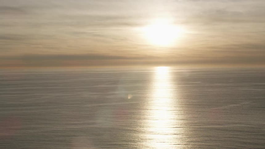 Calm ocean waters reflect the sunset